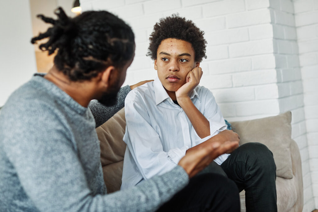 Padre hablando con hijo sobre tema serio